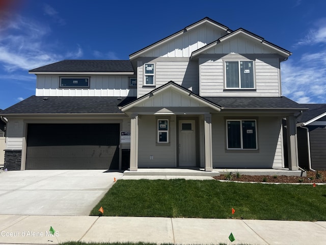 3402 N Cyprus Fox Loop, Post Falls, ID 83854 - view of front of property with board and batten siding, a porch, an attached garage, concrete driveway, and a front lawn