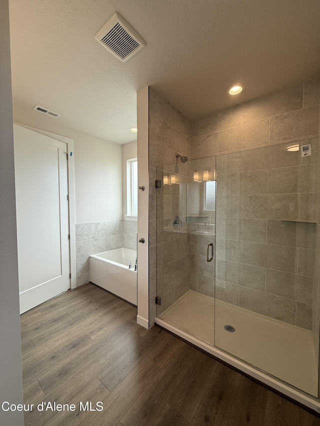 3402 N Cyprus Fox Loop, Post Falls, ID 83854 - bathroom featuring a bath, a shower stall, wood finished floors, and recessed lighting