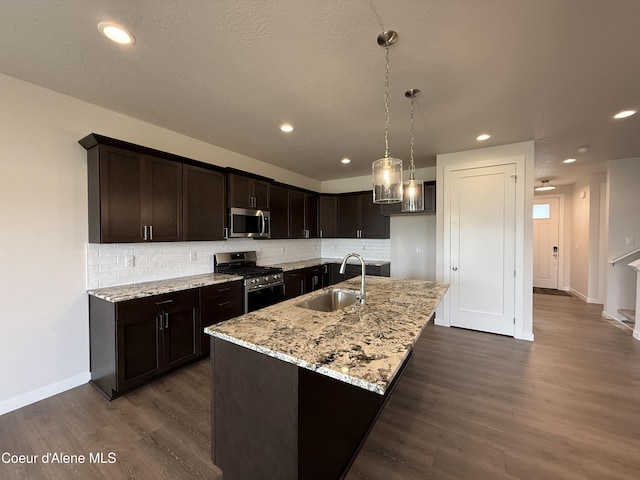 3402 N Cyprus Fox Loop, Post Falls, ID 83854 - kitchen with appliances with stainless steel finishes, decorative backsplash, dark brown cabinetry, dark wood-type flooring, and recessed lighting