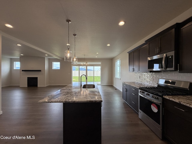 3402 N Cyprus Fox Loop, Post Falls, ID 83854 - kitchen featuring stainless steel appliances, light stone countertops, recessed lighting, dark wood-style flooring, and open floor plan