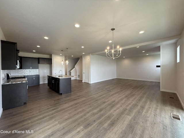 3402 N Cyprus Fox Loop, Post Falls, ID 83854 - kitchen featuring open floor plan, recessed lighting, a chandelier, a kitchen island with sink, and decorative backsplash
