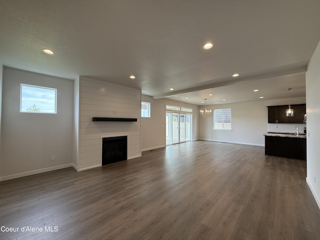 3402 N Cyprus Fox Loop, Post Falls, ID 83854 - unfurnished living room with a fireplace, dark wood finished floors, recessed lighting, and a chandelier