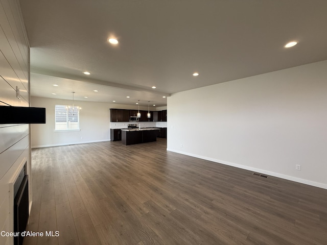 3402 N Cyprus Fox Loop, Post Falls, ID 83854 - unfurnished living room featuring dark wood-style flooring, a chandelier, and recessed lighting