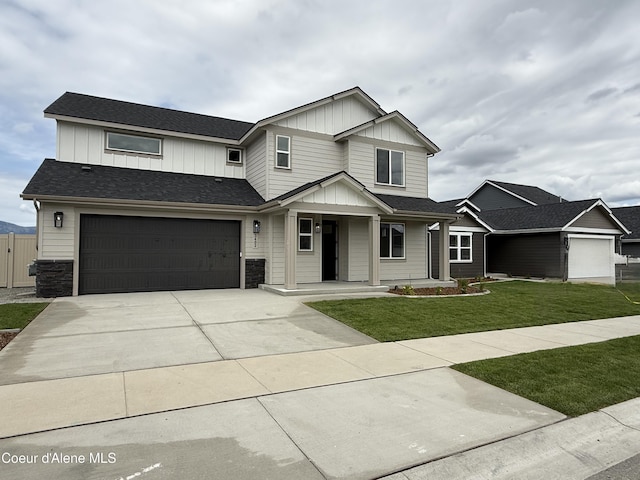3402 N Cyprus Fox Loop, Post Falls, ID 83854 - view of front facade with board and batten siding, a garage, driveway, and covered porch