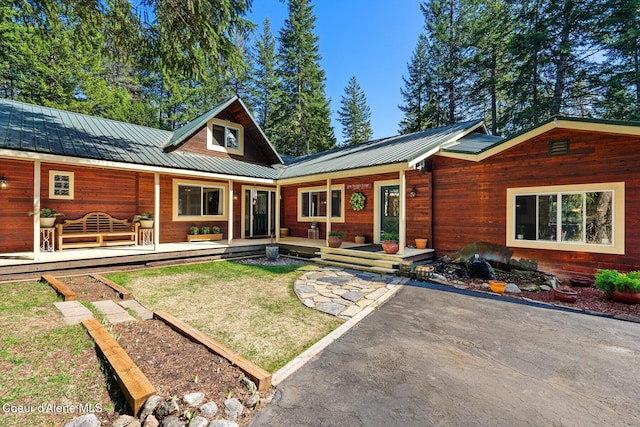 view of front of property featuring a front lawn and metal roof