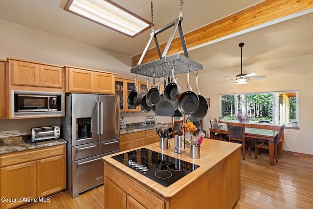 kitchen featuring light wood-style floors, ceiling fan, stainless steel appliances, wooden counters, and a toaster