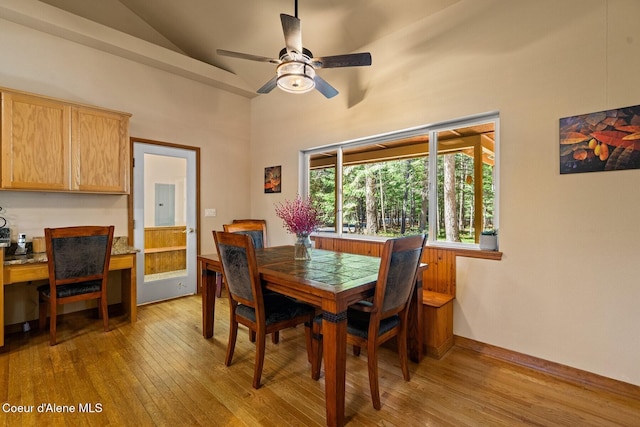 dining area featuring high vaulted ceiling, light wood-style floors, baseboards, and a ceiling fan