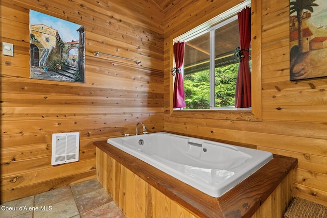 bathroom with wood walls, visible vents, and a bath
