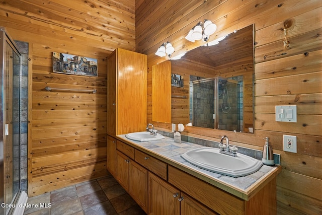 full bath with a stall shower, wooden walls, and a sink