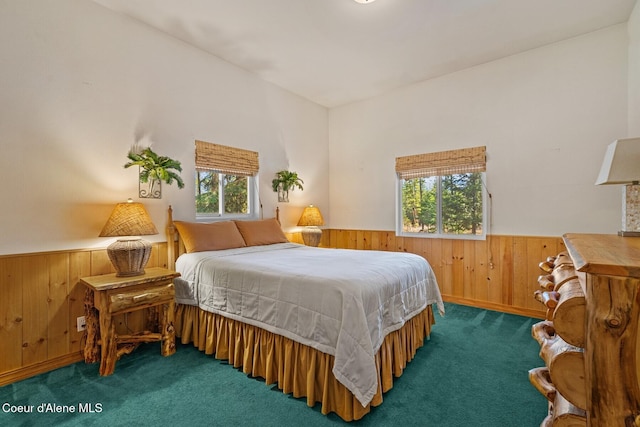 bedroom with wood walls, a wainscoted wall, multiple windows, and carpet floors