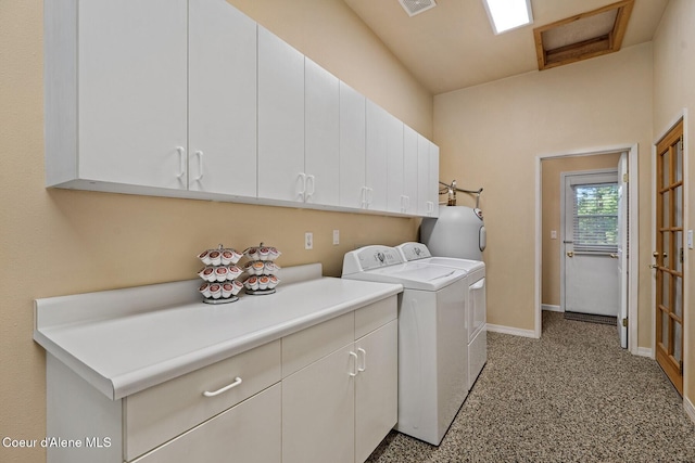 washroom featuring separate washer and dryer, visible vents, water heater, baseboards, and cabinet space