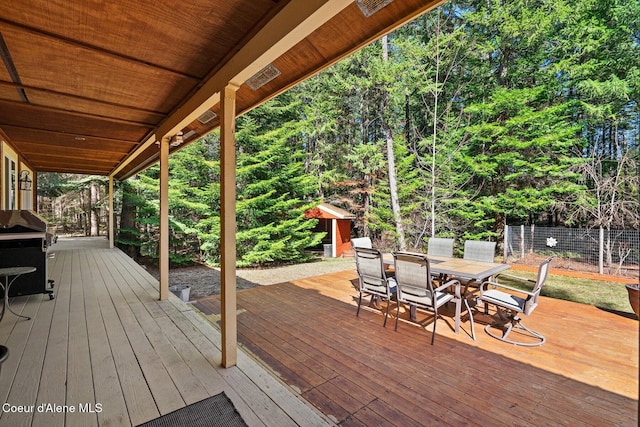 deck with an outbuilding, fence, outdoor dining area, and area for grilling