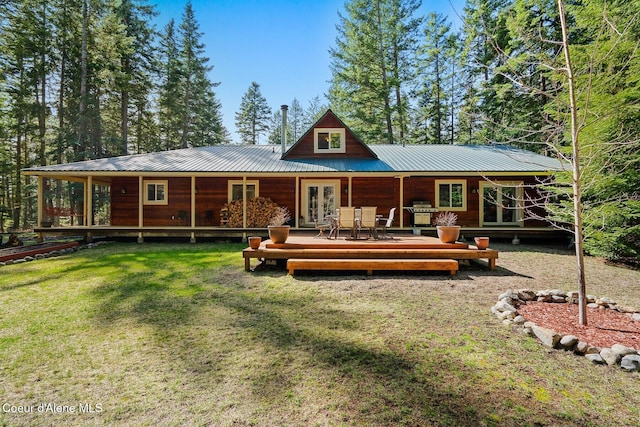 rear view of property with a yard, french doors, and metal roof