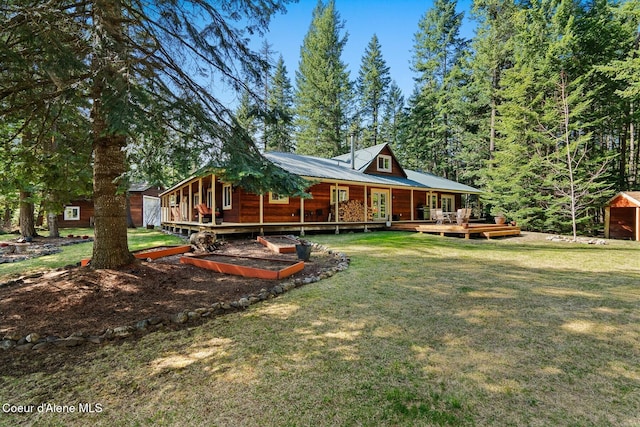 back of house with a wooden deck and a lawn