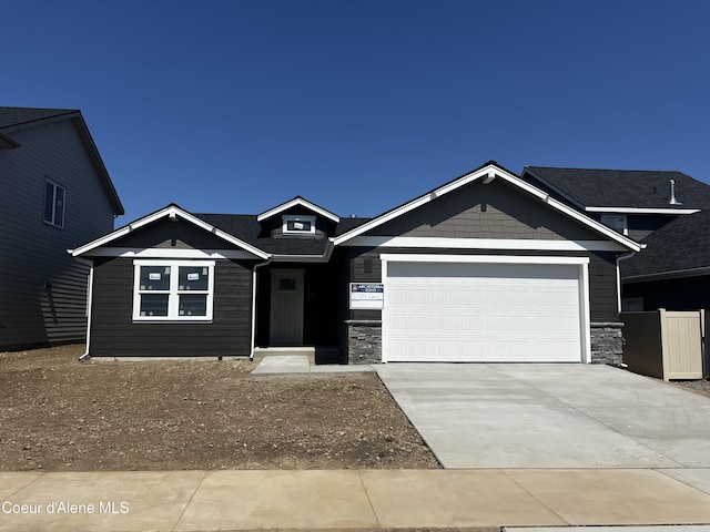 craftsman inspired home featuring driveway, stone siding, and a garage