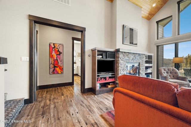 7431 E Cumberland Ct, Hayden, ID 83835 - living room featuring high vaulted ceiling, a fireplace, wood ceiling, wood finished floors, and baseboards