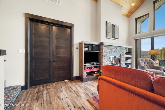 7431 E Cumberland Ct, Hayden, ID 83835 - living area featuring high vaulted ceiling, a fireplace, wood ceiling, and wood finished floors