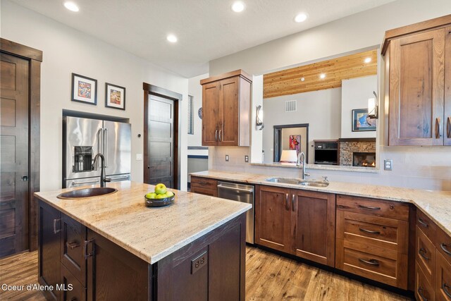 7431 E Cumberland Ct, Hayden, ID 83835 - kitchen with visible vents, a center island, a sink, appliances with stainless steel finishes, and light wood finished floors