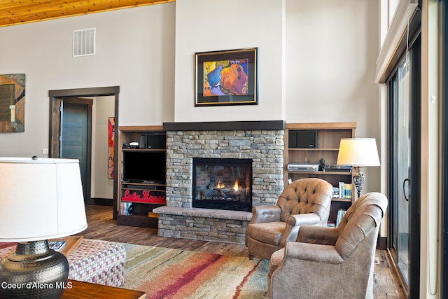 7431 E Cumberland Ct, Hayden, ID 83835 - living area with visible vents, a high ceiling, wood finished floors, and a fireplace