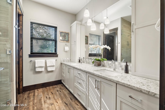 7431 E Cumberland Ct, Hayden, ID 83835 - bathroom with a stall shower, wood finished floors, a sink, and baseboards