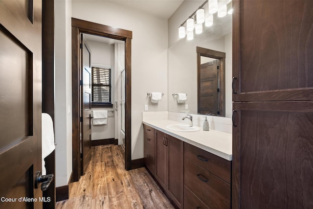 7431 E Cumberland Ct, Hayden, ID 83835 - bathroom with baseboards, vanity, wood finished floors, and walk in shower
