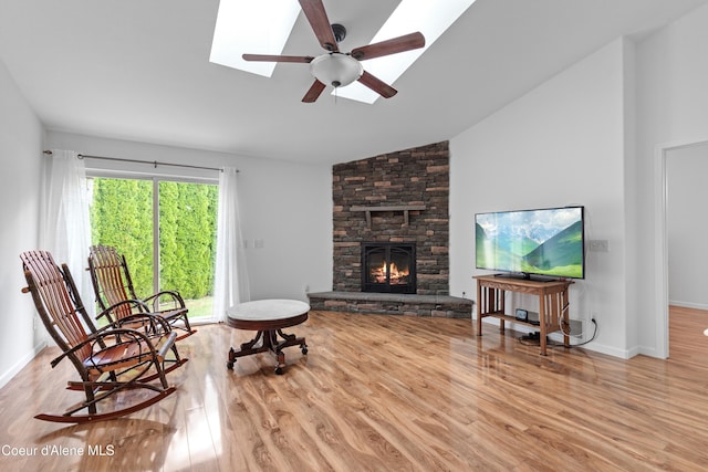 5660 N Loraine St, Coeur Dalene, ID 83815 - living room featuring a fireplace, vaulted ceiling with skylight, and wood finished floors