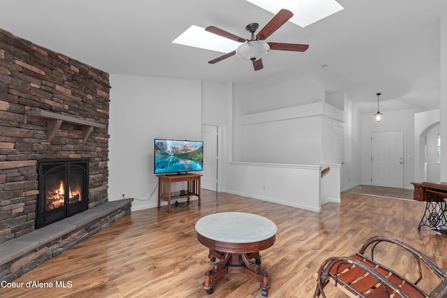 5660 N Loraine St, Coeur Dalene, ID 83815 - living area featuring baseboards, a stone fireplace, a ceiling fan, wood finished floors, and a skylight