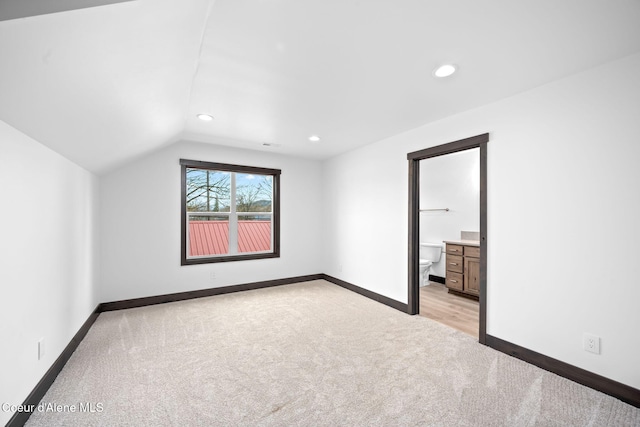 additional living space featuring recessed lighting, vaulted ceiling, light colored carpet, and baseboards