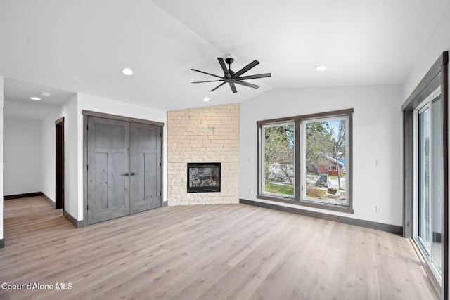 unfurnished living room featuring light wood finished floors, baseboards, lofted ceiling, and ceiling fan