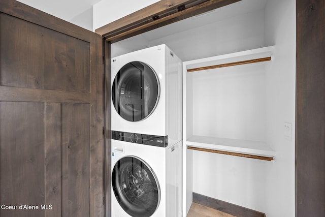 clothes washing area featuring stacked washer / drying machine and laundry area