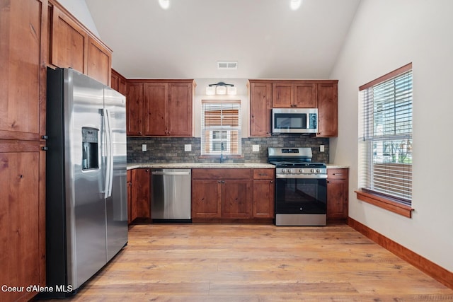 45 Welty Dr, Dover, ID 83825 - kitchen featuring visible vents, a sink, appliances with stainless steel finishes, light wood finished floors, and decorative backsplash