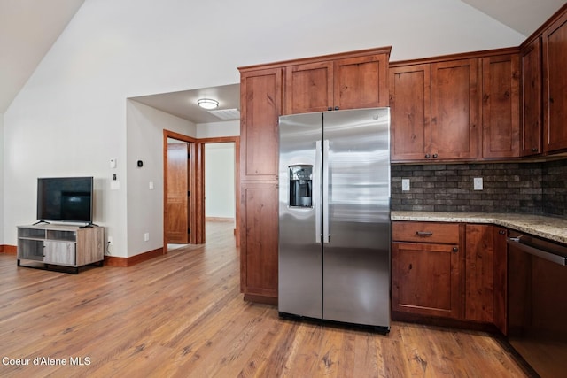 45 Welty Dr, Dover, ID 83825 - kitchen featuring tasteful backsplash, light wood-type flooring, vaulted ceiling, stainless steel appliances, and light stone counters