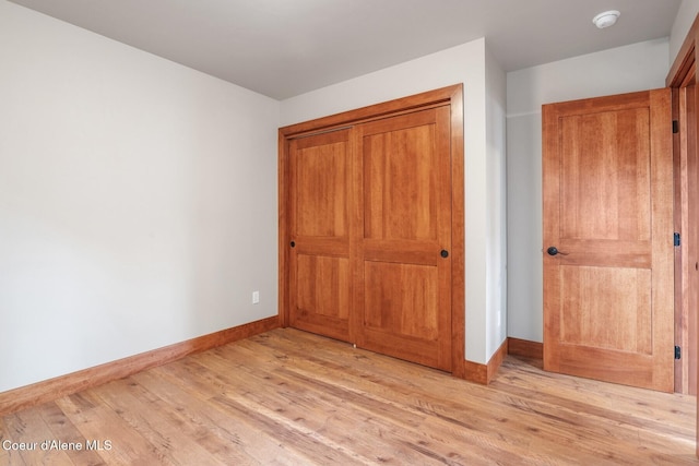 45 Welty Dr, Dover, ID 83825 - unfurnished bedroom featuring a closet, baseboards, and light wood finished floors