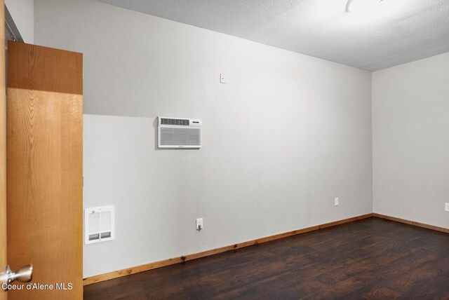 181 E Deer Meadow Ln, Blanchard, ID 83804 - unfurnished room featuring visible vents, an AC wall unit, baseboards, and wood finished floors