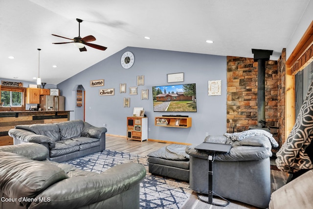181 E Deer Meadow Ln, Blanchard, ID 83804 - living room featuring baseboards, vaulted ceiling, light wood-style flooring, a wood stove, and ceiling fan