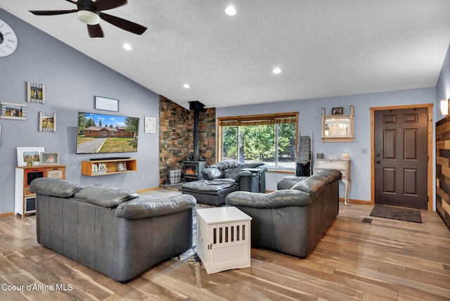 181 E Deer Meadow Ln, Blanchard, ID 83804 - living room with baseboards, vaulted ceiling, light wood-style flooring, a wood stove, and ceiling fan