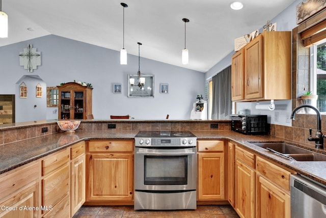181 E Deer Meadow Ln, Blanchard, ID 83804 - kitchen featuring dark stone counters, vaulted ceiling, a sink, hanging light fixtures, and stainless steel appliances