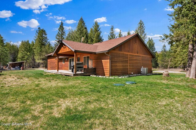 181 E Deer Meadow Ln, Blanchard, ID 83804 - view of side of home with central air condition unit, a wooden deck, a lawn, and board and batten siding