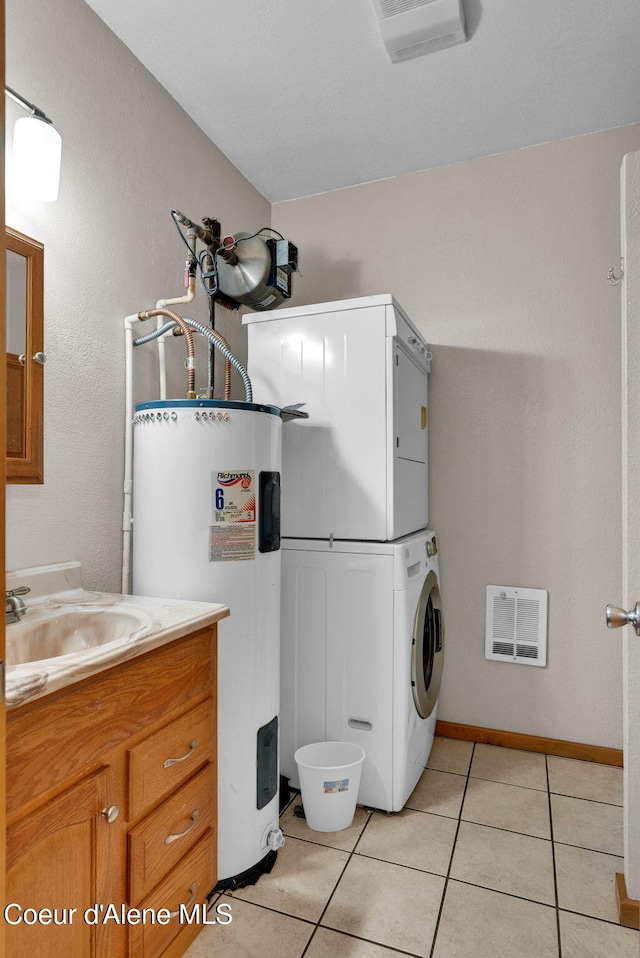 181 E Deer Meadow Ln, Blanchard, ID 83804 - clothes washing area featuring electric water heater, stacked washing maching and dryer, light tile patterned floors, and a sink