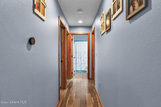 181 E Deer Meadow Ln, Blanchard, ID 83804 - corridor with a textured wall, dark wood-type flooring, and baseboards