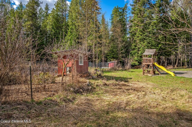 164 Generations Dr, Athol, ID 83801 - view of yard featuring an outdoor structure, fence, and a playground