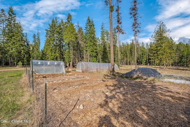 164 Generations Dr, Athol, ID 83801 - view of yard with a view of trees, an outdoor structure, and a greenhouse