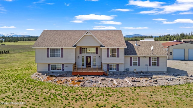 2996 E Briar Ct, Athol, ID 83801 - view of front facade featuring roof with shingles, a deck with mountain view, a detached garage, and a front yard
