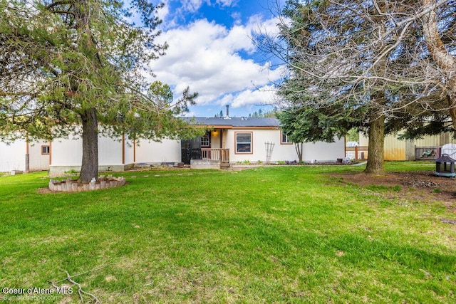 back of property with a yard and fence