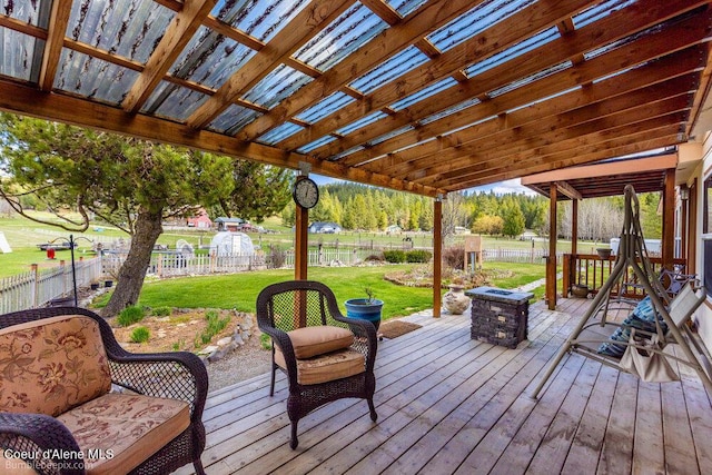 deck featuring a yard, a fenced backyard, a fire pit, and a pergola