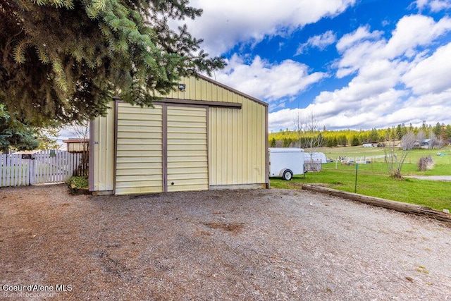 view of outbuilding featuring fence and an outdoor structure