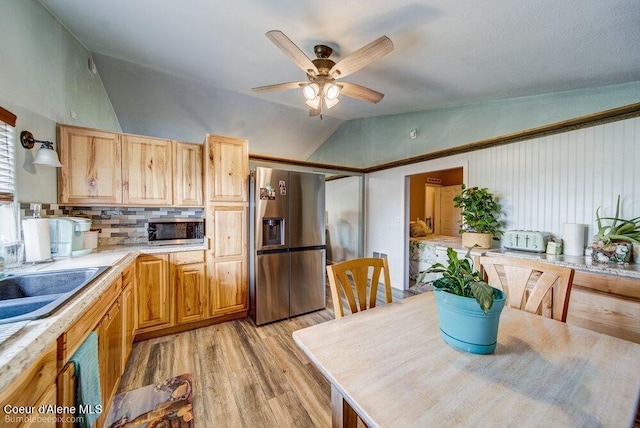 dining room with light wood finished floors, ceiling fan, and lofted ceiling