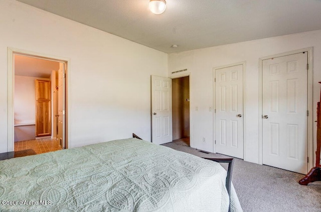 carpeted bedroom featuring visible vents