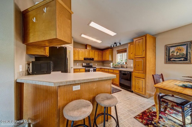 kitchen with a sink, light countertops, a peninsula, black appliances, and lofted ceiling
