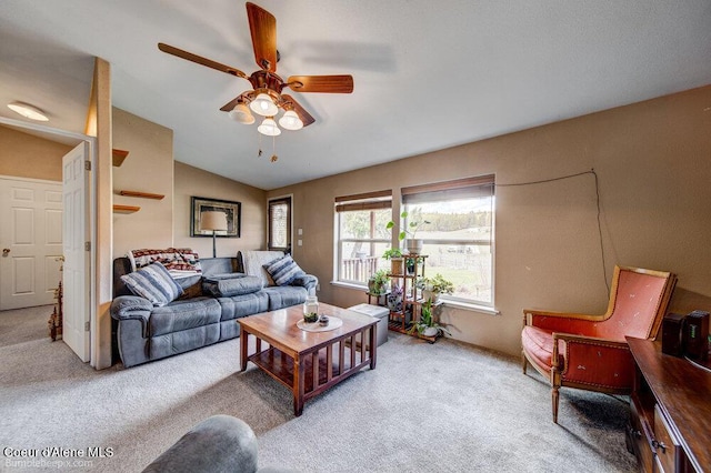 living room featuring ceiling fan, vaulted ceiling, and light carpet